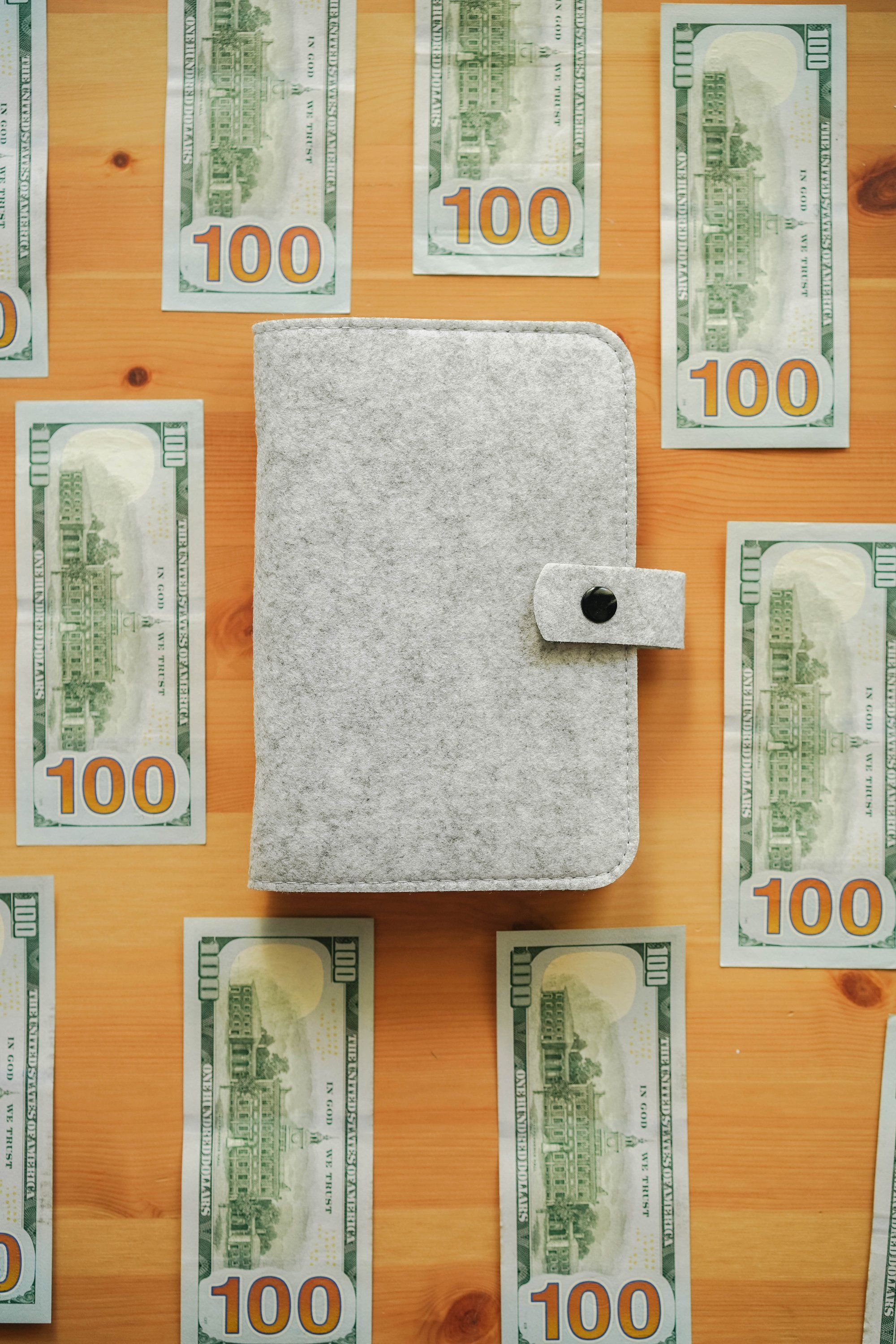 Dollar Bills Around Book Binder on Wooden Table